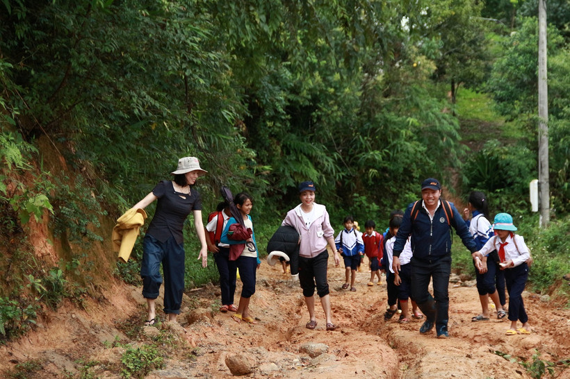 Cô Hồ Thị Thùy Vân (ngoài cùng bên trái) cùng đồng nghiệp vận động đưa học sinh đến lớp. Ảnh: baotintuc.vn