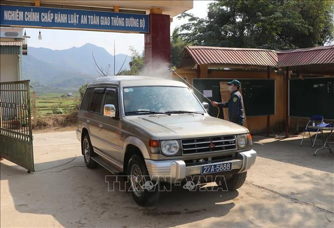 Tiến hành phun khử trùng, sát khuẩn tất cả các loại phương tiện vào khu cách ly tại huyện Mường Ảng (Điện Biên). Ảnh: Xuân Tiến-TTXVN