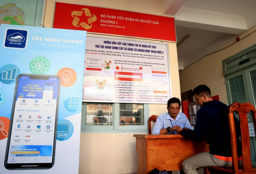 Cán bộ UBND Phường 1 (thành phố Tây Ninh, tỉnh Tây Ninh) hướng dẫn người dân sử dụng tài khoản dịch vụ công quốc gia. Ảnh: Hồng Đạt - TTXVN