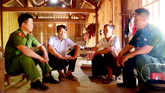 Ông Sồng A Tủa cùng Công an và Bộ đội Biên phòng tuyên truyền, vận động anh Sồng A Nhà cai nghiện ma túy thành công. Ảnh: cand.com.vn