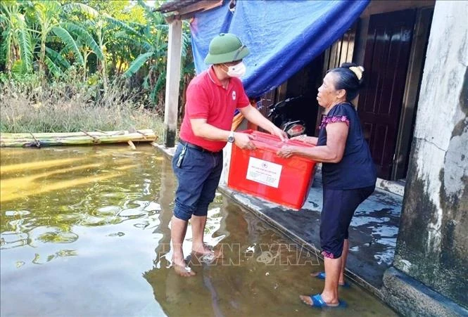 Hội Chữ thập đỏ tỉnh Quảng Bình trao tặng thùng hàng gia đình cho hộ dân bị ảnh hưởng tại rốn lũ xã Tân Ninh, huyện Quảng Ninh, tỉnh Quảng Bình. Ảnh: Võ Dung -TTXVN