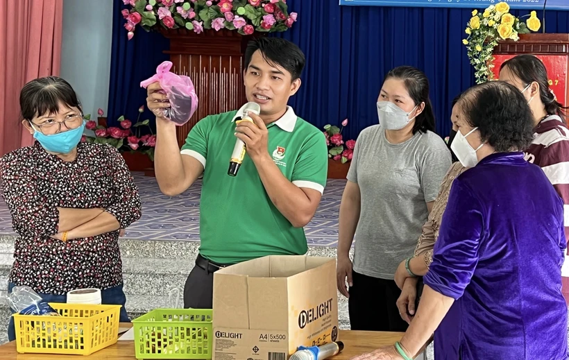 Hướng dẫn cách phân loại rác tại nguồn cho đại biểu tham dự chương trình. Ảnh: Hồng Giang - TTXVN