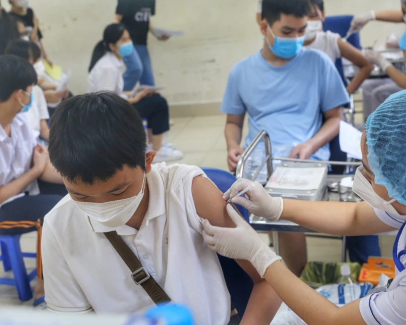 Nhân viên y tế phường Minh Khai (Hà Nội) tiêm mũi nhắc lại cho các em học sinh trường THCS Hà Huy Tập. Ảnh: Tuấn Đức - TTXVN