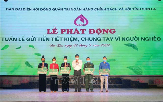 Bí thư Tỉnh ủy Sơn La Nguyễn Hữu Đông trao biểu trưng số tiền hỗ trợ vay vốn cho các hộ gia đình nghèo, gia đình chính sách trên địa bàn thành phố Sơn La. Ảnh: Quang Quyết-TTXVN