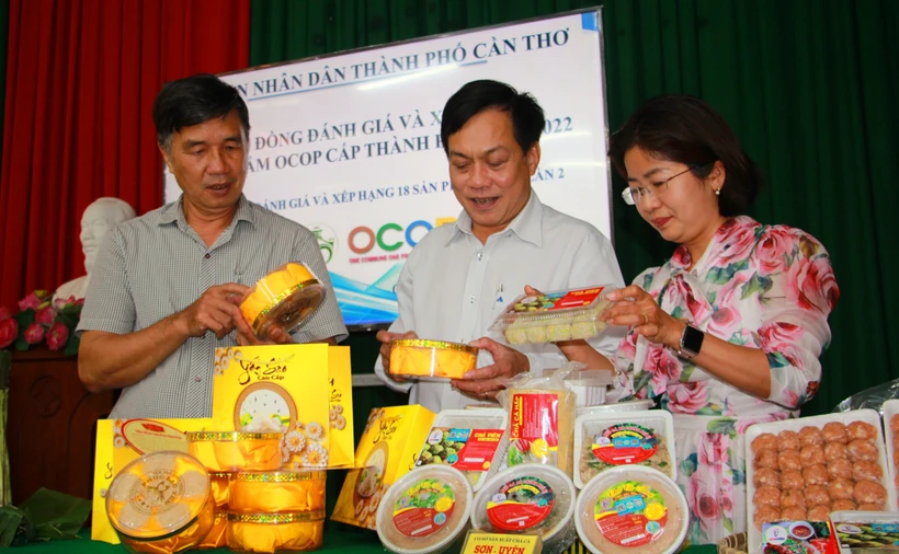 Thành viên Hội đồng đánh giá, xếp hạng sản phẩm OCOP xem xét các sản phẩm. Ảnh: Thu Hiền - TTXVN