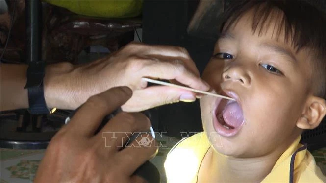 Cơ quan y tế huyện Bù Đăng triển khai đội ngũ y bác sĩ kiểm tra sức khỏe, tiêm vắc xin cho những người tiếp xúc gần với bệnh nhân bạch hầu. Ảnh: TTXVN