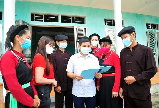 Ông Triệu Văn Xanh (giữa), trưởng thôn Ngòi Lộc, xã Minh Khương, huyện Hàm Yên (Tuyên Quang) tuyên truyền chính sách pháp luật cho nhân dân trong thôn. Ảnh: Vũ Quang - TTXVN