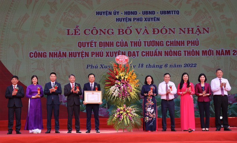 Các đồng chí lãnh đạo thành phố Hà Nội trao Quyết định của Thủ tướng Chính phủ và tặng hoa chúc mừng huyện Phú Xuyên đạt chuẩn nông thôn mới năm 2020.