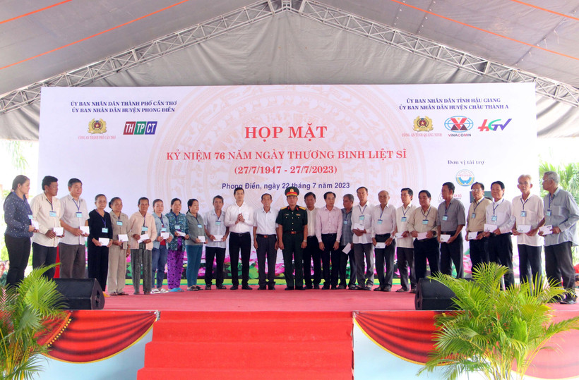 Ban tổ chức trao quà cho các hộ gia đình chính sách và người có công. Ảnh: Trung Kiên - TTXVN