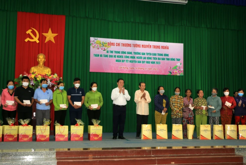 Trưởng Ban Tuyên giáo Trung ương Nguyễn Trọng Nghĩa trao quà cho hộ nghèo và công nhân lao động có hoàn cảnh khó khăn tỉnh Đồng Tháp. Ảnh: Nhựt An - TTXVN