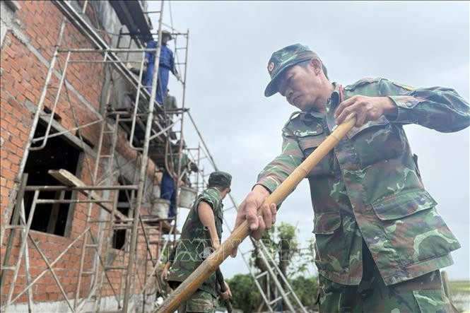 Chiến sĩ Quân khu 5 giúp xây nhà cho người dân tại xã Hòa Thịnh. Ảnh: Tường Quân/TTXVN