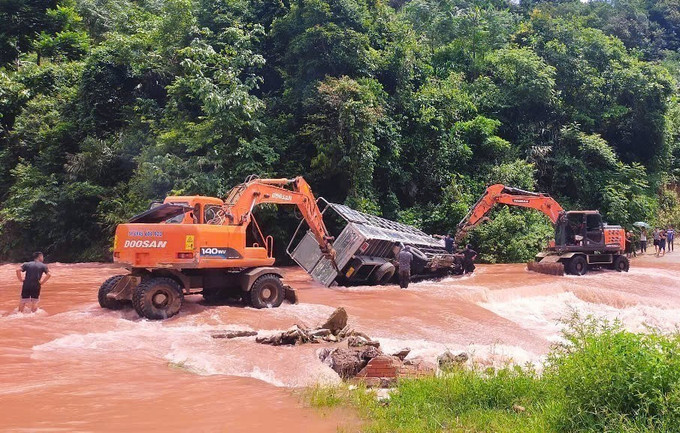Xe tải bị lật nghiêng khi đi qua điểm bị ngập, dòng chảy mạnh. Lực lượng chức năng, người dân địa phương phải chèn bánh và dùng xe cẩu nỗ lực kéo xe tải ra khỏi vị trí nguy hiểm. Ảnh: TTXVN phát Xe tải bị lật nghiêng khi đi qua điểm bị ngập, dòng chảy mạnh. Lực lượng chức năng, người dân địa phương phải chèn bánh và dùng xe cẩu nỗ lực kéo xe tải ra khỏi vị trí nguy hiểm. Ảnh: TTXVN phát