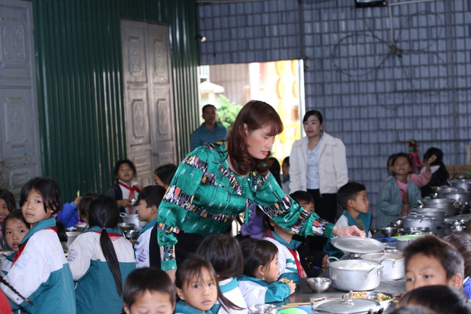 Giơ ăn trưa của học sinh bán trú, cô Trần Thị Thao ân cần chia từng phần cơm cho các em. dao-san-281025-1.jpg
