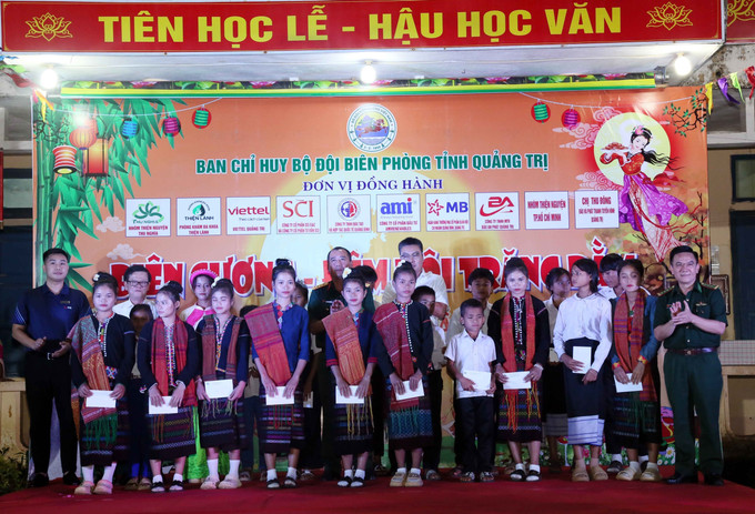 Lãnh đạo Chỉ huy Bộ đội biên phòng Quảng Trị và các đơn vị tài trợ tặng học bổng cho các em học sinh Việt Nam và Lào tại chương trình. Ảnh: Tá Chuyên/TTXVN Lãnh đạo Chỉ huy Bộ đội biên phòng Quảng Trị và các đơn vị tài trợ tặng học bổng cho các em học sinh Việt Nam và Lào tại chương trình. Ảnh: Tá Chuyên/TTXVN
