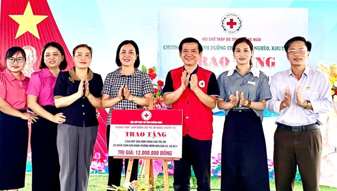 Trao bảng tượng trưng trao tặng hơn 2.600 hộp sữa Fami canxi trị giá 12 triệu đồng cho học sinh trường mầm non Đăk Xú. Ảnh: TTXVN phát Chú thích ảnh
