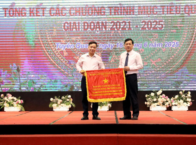 Ông Nguyễn Thế Giang, Phó Chủ tịch UBND tỉnh Tuyên Quang tặng Cờ thi đua của UBND tỉnh cho tập thể có thành tích xuất sắc trong tổ chức, triển khai thực hiện các Chương trình mục tiêu quốc gia. Ảnh: Quang Cường/TTXVN Chú thích ảnh