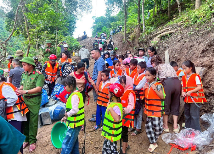 Lực lượng chức năng hỗ trợ đưa học sinh, giáo viên qua sông đến trường bằng thuyền. Ảnh: TTXVN phát Lực lượng chức năng hỗ trợ đưa học sinh, giáo viên qua sông đến trường bằng thuyền. Ảnh: TTXVN phát