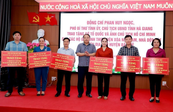 Chủ tịch UBND tỉnh Hà Giang Phan Huy Ngọc trao biểu trưng Cờ Tổ quốc và ảnh Chủ tịch Hồ Chí Minh cho lãnh đạo 6 xã mới sau sáp nhập của huyện Bắc Mê. Ảnh: TTXVN phát tang-co-240625-2.jpg