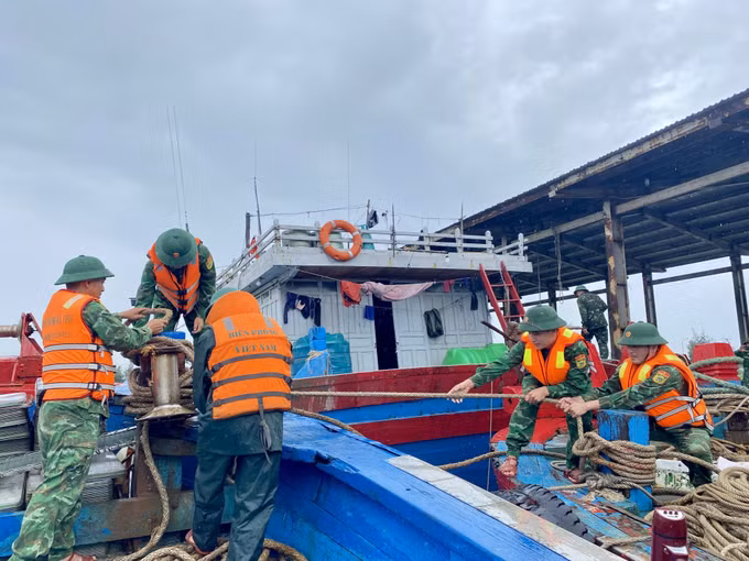 Bộ đội biên phòng hỗ trợ ngư dân gia cố, chằng néo tàu thuyền.