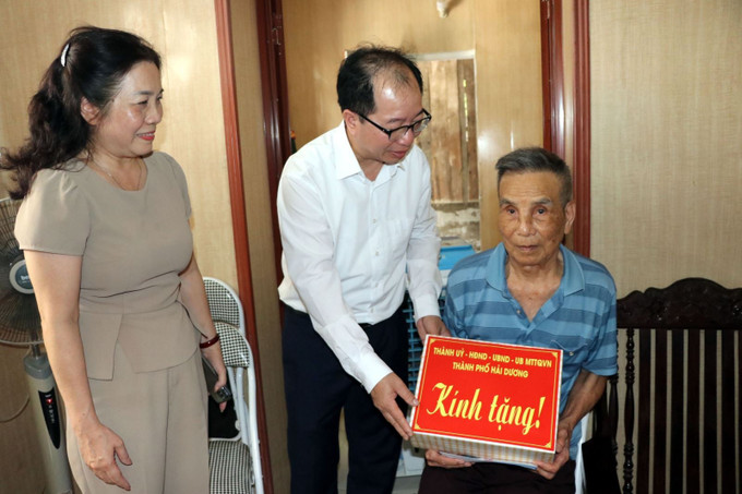 Lãnh đạo thành phố Hải Dương tặng quà các hộ gia đình chính sách, hộ nghèo, hộ cận nghèo tại thành phố Hải Dương vừa được cải tạo nhà ở. Ảnh: Mạnh Tú/TTXVN Chú thích ảnh