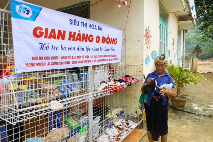 Người dân vùng lũ bản Pá Vạt, xã Mường Luân (Điện Biên) lựa chọn món hàng thiết yếu tại gian hàng 0 đồng do siệu thị Hoa Ba triển khai. Ảnh: Phan Quân/TTXVN dien-bien-050825-1.jpg