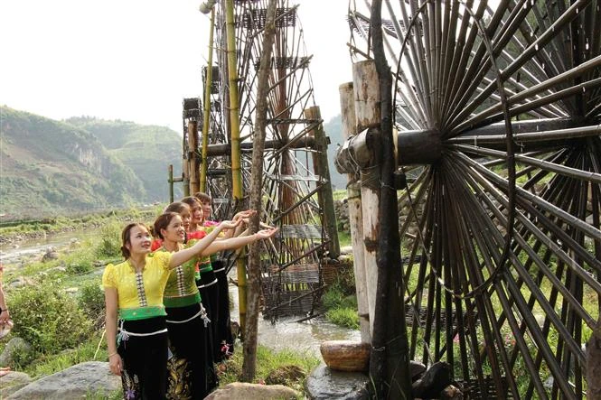 Các cô gái dân tộc Thái bên những guồng nước ở xã Ngọc Chiến, huyện Mường La, tỉnh Sơn La. Ảnh: Nguyễn Cường - TTXVN