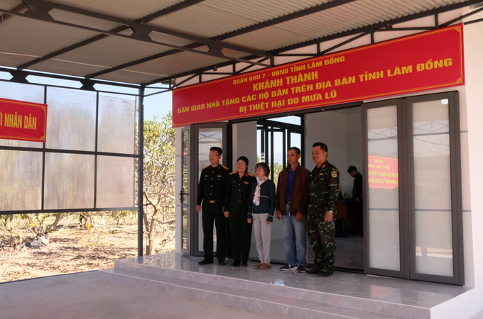 Gia đình ông Mai Ngọc Hiệp (thôn Lạc Thiện 1, xã D’ran) chụp hình cùng với các lực lượng của Quân khu 7 trong lễ khánh thành và bàn giao nhà sáng 31/12.