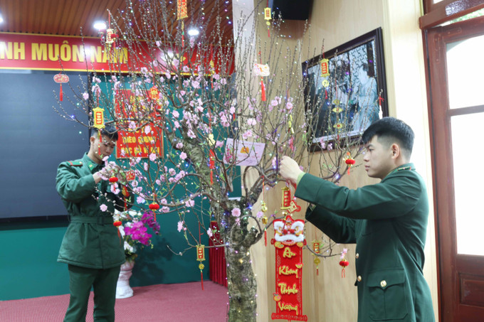 Cán bộ, chiến sĩ Đồn Biên phòng Cửa khẩu quốc tế Hữu Nghị (Lạng Sơn) chăm sóc, trang trí cây đào Tết tại đơn vị.