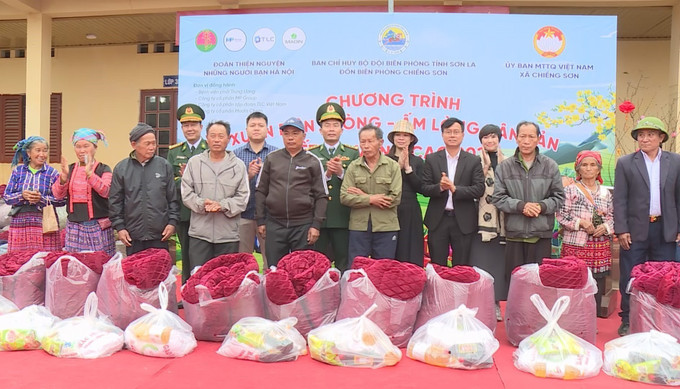 Tặng quà cho các gia đình có hoàn cảnh khó khăn tại Chương trình “Xuân biên phòng, ấm lòng dân bản” ở xã biên giới Chiềng Sơn, tỉnh Sơn La. Ảnh: TTXVN phát.