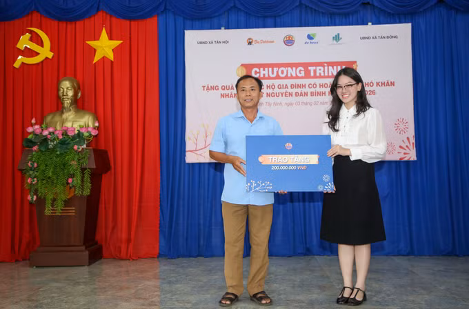 Bà Vũ Hoàng Ái My, Phó Giám đốc Quỹ Từ thiện DHN, trao tặng 200 triệu đồng tiền mặt hỗ trợ công tác an sinh xã hội cho đại diện xã Tân Hội, tỉnh Tây Ninh.
