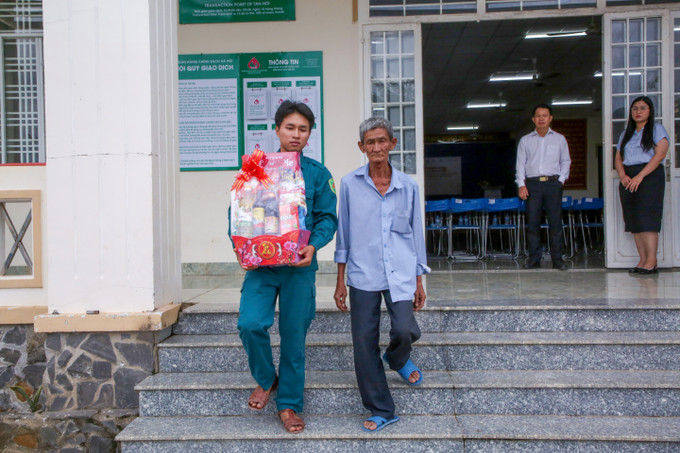 Ông Nguyễn Thành Tâm, 65 tuổi, ngụ ấp Hội Thành, xã Tân Hội, tỉnh Tây Ninh, được lực lượng Dân quân tự vệ hỗ trợ mang quà ra tận xe.