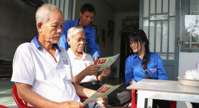 Đoàn viên, thanh niên xã Vĩnh Thuận Đông phổ biến thông tin bầu cử đến đồng bào Khmer ấp 6B. Ảnh: Hồng Thái/TTXVN