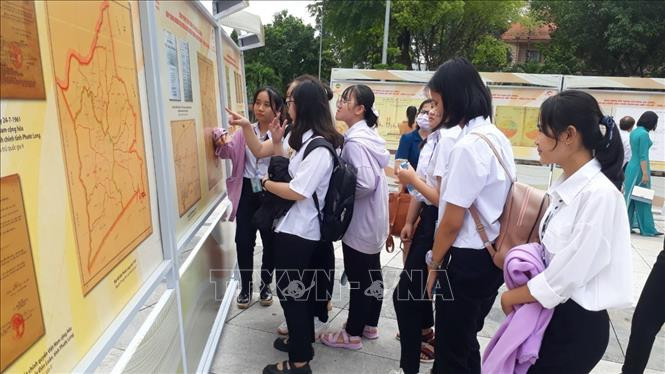 Các em học sinh tham quan triển lãm. Ảnh: K GỬIH – TTXVN Triển lãm tài liệu lưu trữ lịch sử “Bình Phước kháng chiến, kiến quốc 1954-1975” ảnh 4