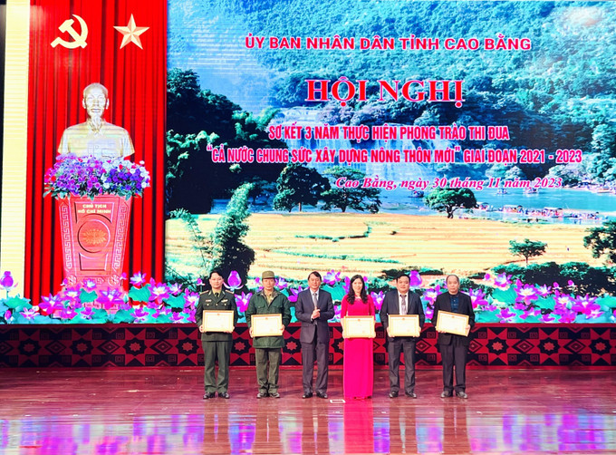 Các cá nhân, hộ gia đình có thành tích xuất sắc nhận Bằng khen của Chủ tịch UBND tỉnh Cao Bằng. Ảnh: Chu Hiệu-TTXVN Đẩy nhanh tiến độ xây dựng nông thôn mới tại Cao Bằng ảnh 2