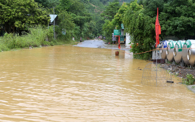 Mưa lớn làm ngập một đoạn trên quốc lộ 70, đoạn qua xã bản Cầm, huyện Bảo Thắng. Ảnh: Quốc Khánh - TTXVN Mưa lũ gây nhiều thiệt hại tại Lào Cai ảnh 4