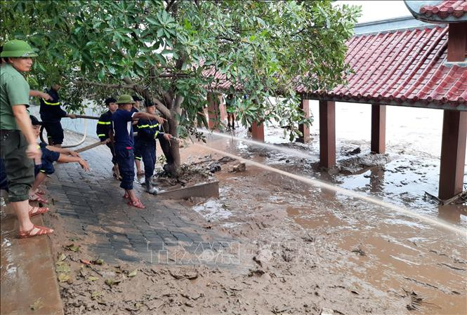 Lực lượng công an tổ chức thu dọn bùn đất tại khu vực bến thả hoa bờ Nam sông Thạch Hãn (Quảng Trị). Ảnh: Hồ Cầu-TTXVN Miền Trung ứng phó với biến đổi khí hậu (Bài 4) ảnh 2