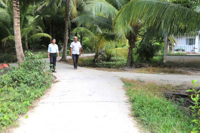 Đường đi do ông Kim Ruône (bên phải) Bí thư chi bộ ấp Bót Chếch, xã Lương Hòa, huyện Châu Thành - người có uy tín vùng đồng bào dân tộc Khmer của ấp hiến đất xây dựng. Ảnh: Thanh Hòa - TTXVN Phát huy vai trò người có uy tín vùng đồng bào dân tộc thiểu số trong xây dựng nông thôn mới ảnh 2