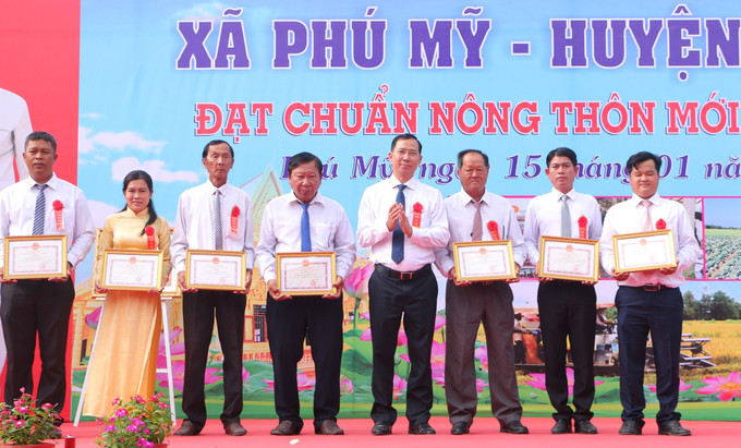 Ông Phạm Tuân, Bí thư Huyện ủy Mỹ Tú, trao Giấy khen của UBND huyện cho các cá nhân có thành tích xuất sắc trong xây dựng nông thôn mới. Ảnh: Tuấn Phi-TTXVN Xã đông người dân tộc Khmer nhất Sóc Trăng đạt chuẩn nông thôn mới ảnh 2