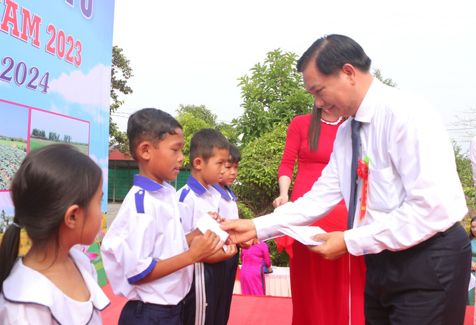 Chủ tịch UBND tỉnh Trần Văn Lâu trao học bổng cho học sinh dân tộc Khmer xã Phú Mỹ. Ảnh: Tuấn Phi-TTXVN Xã đông người dân tộc Khmer nhất Sóc Trăng đạt chuẩn nông thôn mới ảnh 1
