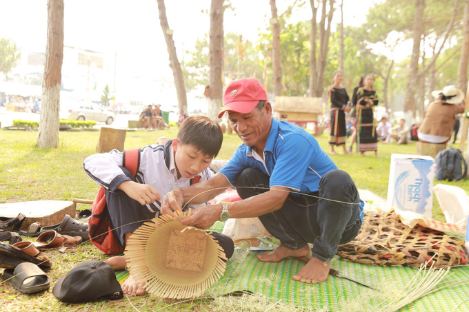 Em Bùi Gia Huy (lớp 7- Trường THCS Nguyễn Huệ, thành phố Pleiku, tỉnh Gia Lai) tỉ mẩn học cách đan lát. Ảnh: Quang Thái - TTXVN Gia Lai bảo tồn và quảng bá văn hóa truyền thống của đồng bào dân tộc thiểu số ảnh 9
