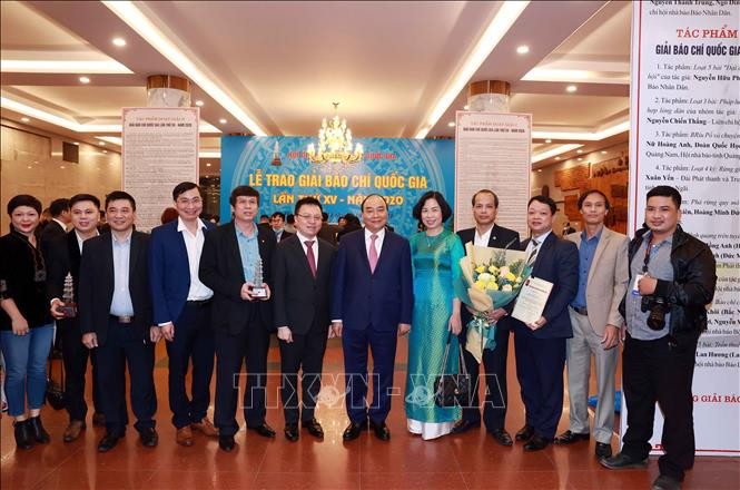 Chủ tịch nước Nguyễn Xuân Phúc, Tổng biên tập báo Nhân Dân Lê Quốc Minh và Tổng giám đốc TTXVN Vũ Việt Trang cùng các nhà báo của TTXVN. Ảnh: Thống Nhất – TTXVN Danh sách các tác phẩm xuất sắc đoạt Giải Báo chí Quốc gia lần thứ XV - năm 2020 ảnh 1
