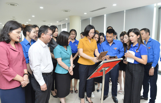 Tổng Giám đốc Thông tấn xã Việt Nam Vũ Việt Trang xem thông tin giới thiệu các khu di tích của TTXVN được tích hợp sẵn trong mã QR. Ảnh: Minh Đức – TTXVN Công trình thanh niên “Chuyển đổi số trong giới thiệu các Khu Di tích của TTXVN” ảnh 2