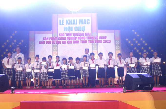 Trao quà cho học sinh nghèo học giỏi. Ảnh: Thanh Hòa - TTXVN Khai mạc hội chợ mua sắm cho lễ hội Ok Om Bok ảnh 4