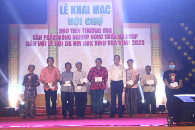 Trao quà cho các hộ có hoàn cảnh khó khăn. Ảnh: Thanh Hòa - TTXVN Khai mạc hội chợ mua sắm cho lễ hội Ok Om Bok ảnh 3