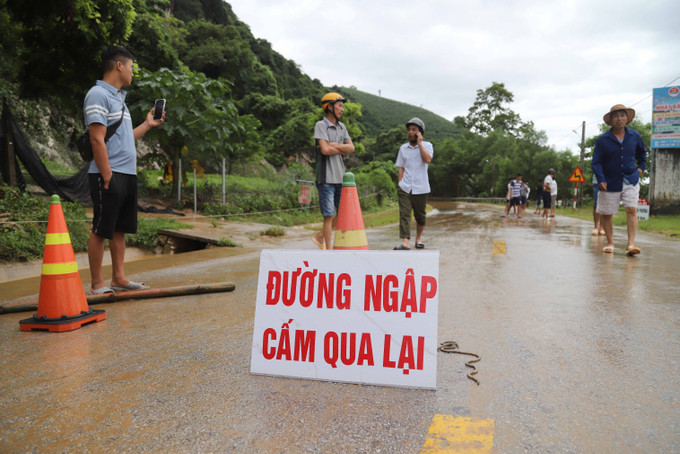 Lực lượng chức năng lập chốt chặn nhằm đảm bảo an toàn cho người và phương tiện do nước và bùn đất làm ngập Quốc lộ 48. Ảnh: Xuân Tiến - TTXVN Nghệ An tập trung khắc phục hậu quả thiên tai, đảm bảo an toàn cho người dân bị cô lập do mưa lũ ảnh 4