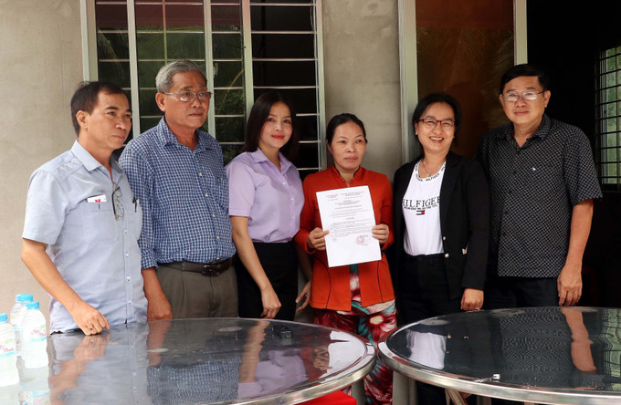 Trao quyết định bàn giao nhà Đại đoàn kết cho hộ bà Trần Thị Mỹ Vân. Ảnh: Trung Kiên - TTXVN Thông tấn xã Việt Nam chung tay hỗ trợ nạn nhân bị ảnh hưởng chất độc da cam tại Sóc Trăng ảnh 2