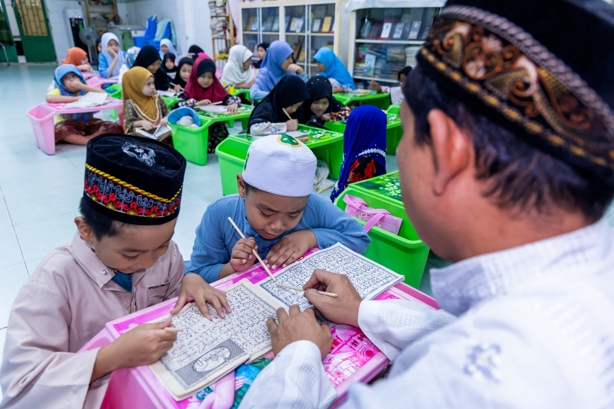 Các em nhỏ tập đánh vần chữ Chăm tại lớp học của thầy Muhammad Osry, Thánh đường Jamiul Anwar, phường Chánh Hưng. lophoctiengcham9.jpg