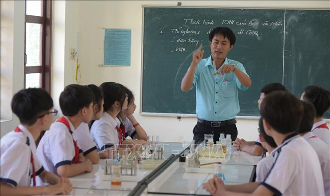 Thầy Hồ Thanh Tùng hướng dẫn học sinh làm thí nghiệm. Ảnh: TTXVN phát Thầy giáo trẻ gieo mầm tri thức ảnh 1