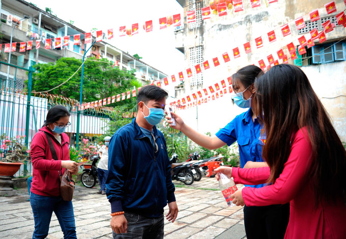 Cử tri tham gia bầu cử được kiểm tra thân nhiệt và được hướng dẫn thực hiện quy định 5K của Bộ Y tế tại khu vực bỏ phiếu số 70 - Hội quán Hà Chương ở phường 14, quận 5, Thành phố Hồ Chí Minh. Cử tri người Hoa quận 5 hân hoan đi bầu cử ảnh 6