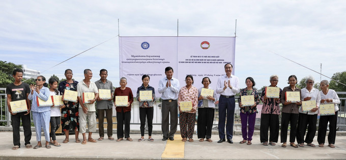 Đoàn Việt Nam và Campuchia trao quà cho các hộ gia đình người Campuchia và người Việt Nam có hoàn cảnh đặc biệt khó khăn tại khu vực biên giới Việt Nam - Campuchia. Ảnh: Thanh Sang - TTXVN. Bàn giao nhà Đại đoàn kết và tặng quà cho người dân vùng biên giới Việt Nam - Campuchia ảnh 1